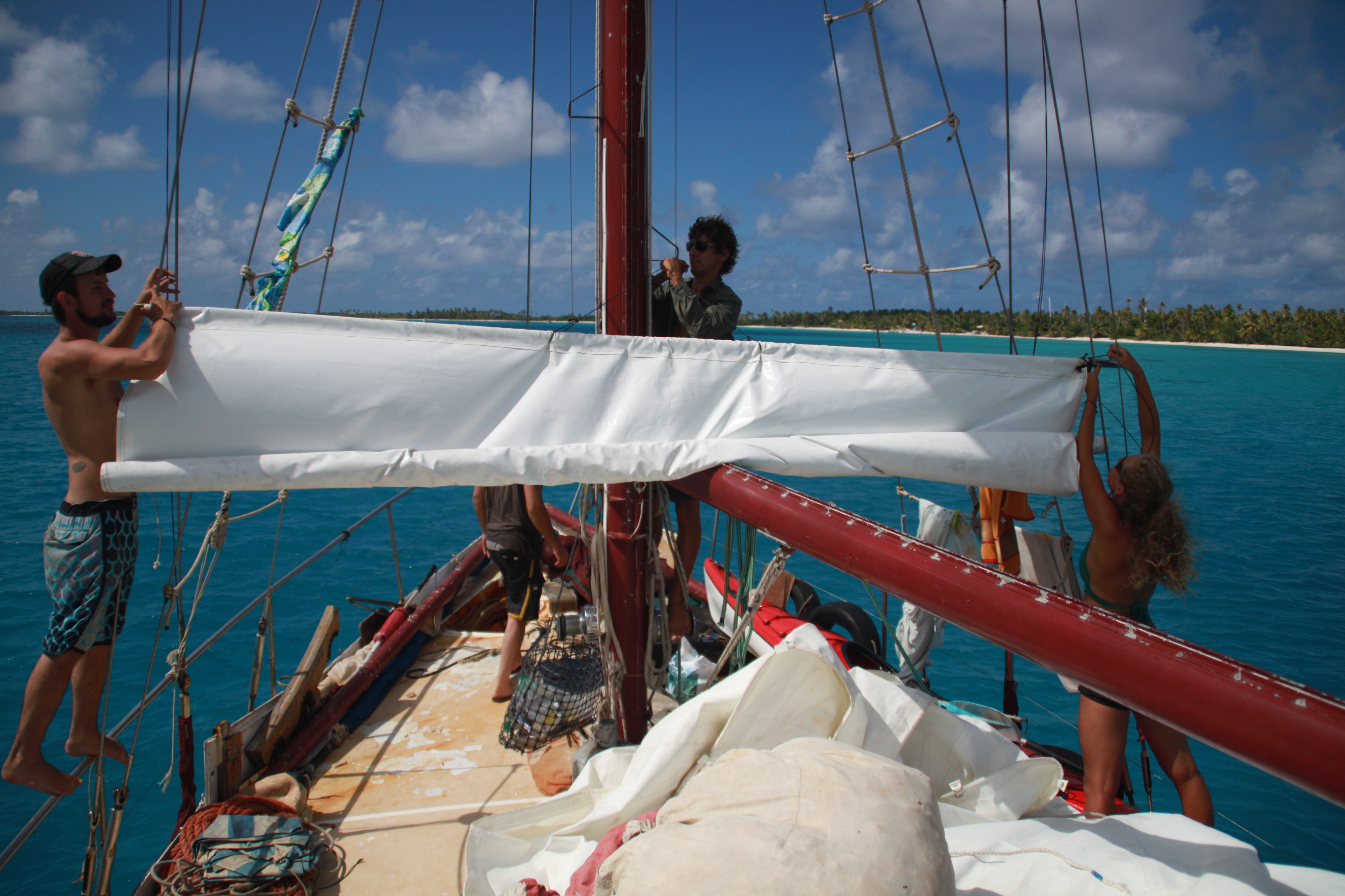 Crew members working together on Karaka's sails